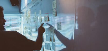 person pointing white paper on wall