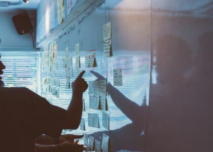 person pointing white paper on wall